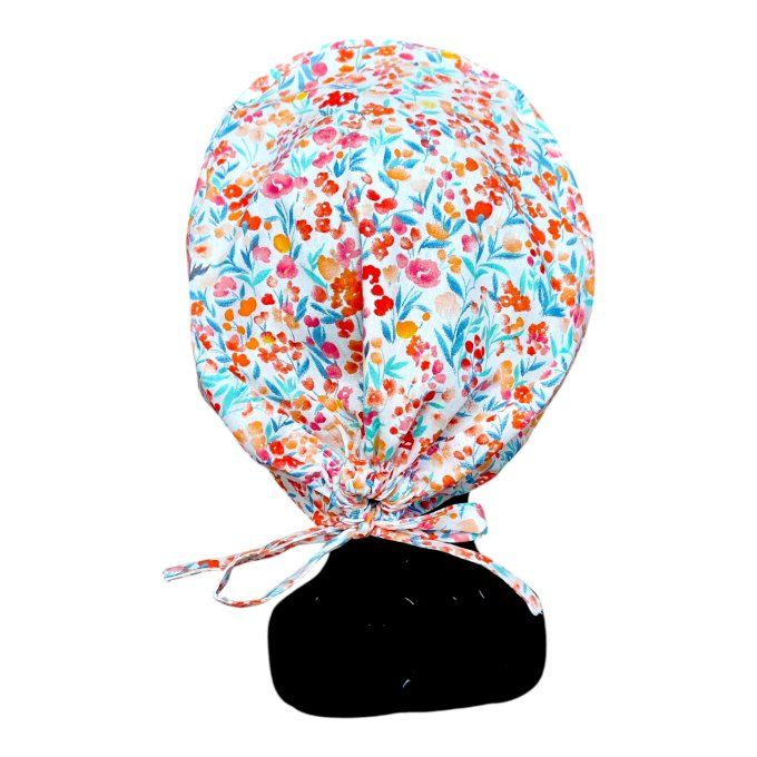 ses fines fleurs aux tons orange, corail, rouge et turquoise, disposées sur un fond blanc cassé, cré