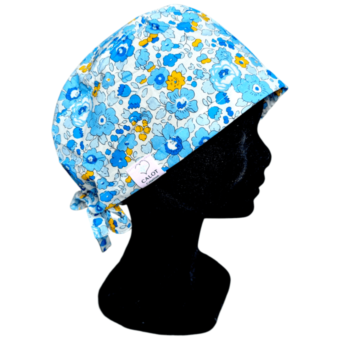 Avec son imprimé de fleurs bleues ponctuées de touches jaunes vives, ce calot rappelle la fraîcheur 