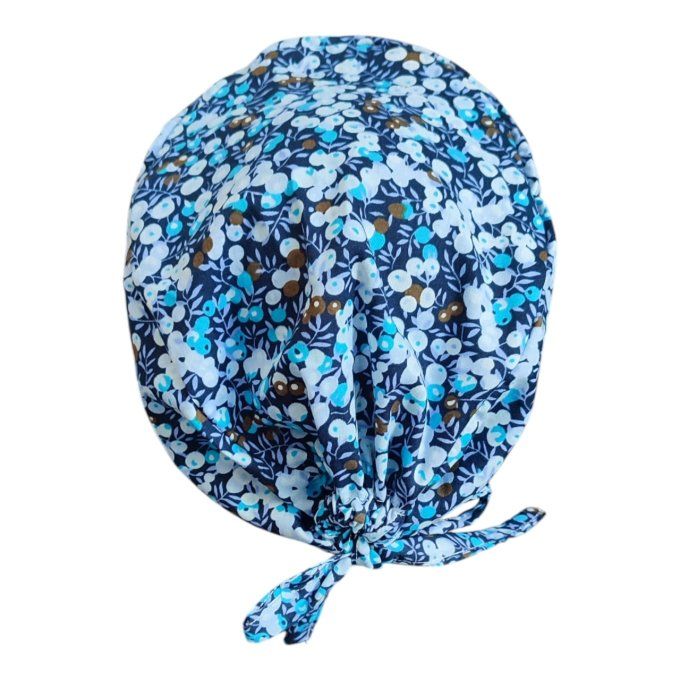 son tissu bleu foncé est rehaussé de petites fleurs délicates en nuances de bleu, blanc et doré, app