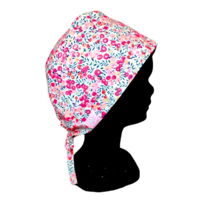 son tissu blanc lumineux est orné de délicates fleurs aux nuances de rose, bleu et rouge, apportant 