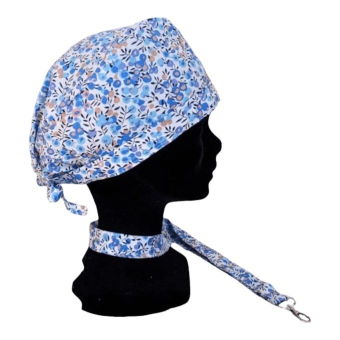 son tissu blanc est délicatement orné de fleurs dans des nuances de bleu et de beige, offrant une to