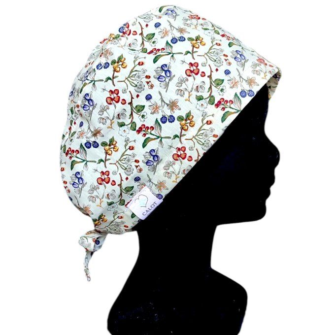 son tissu blanc cassé est sublimé par un motif éclatant de fleurs dans des tons orangés, verts et to