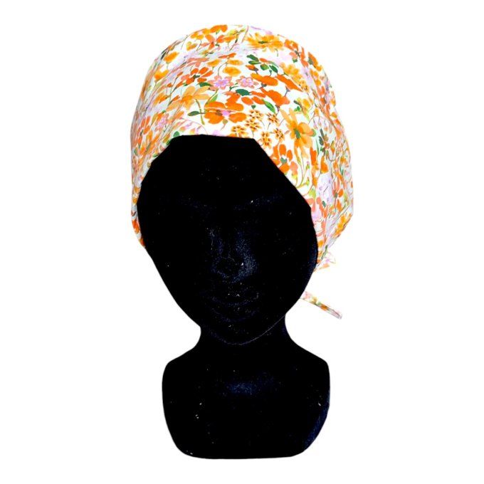 son tissu blanc cassé est sublimé par un motif éclatant de fleurs dans des tons orangés, verts et to