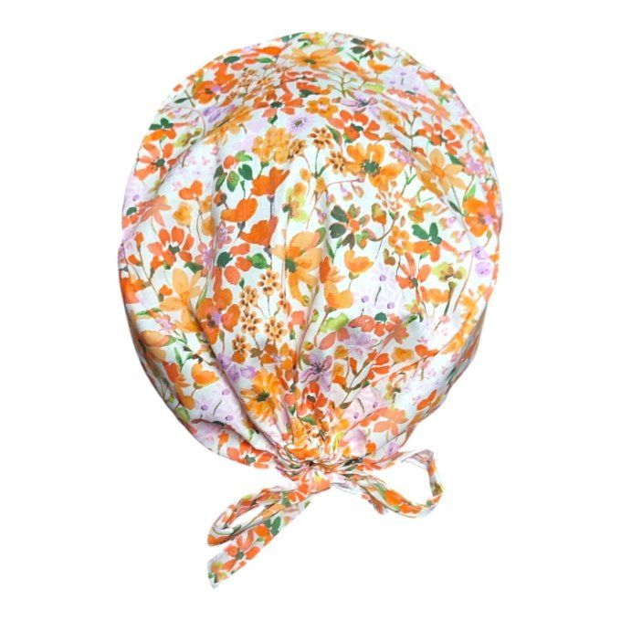 son tissu blanc cassé est sublimé par un motif éclatant de fleurs dans des tons orangés, verts et to