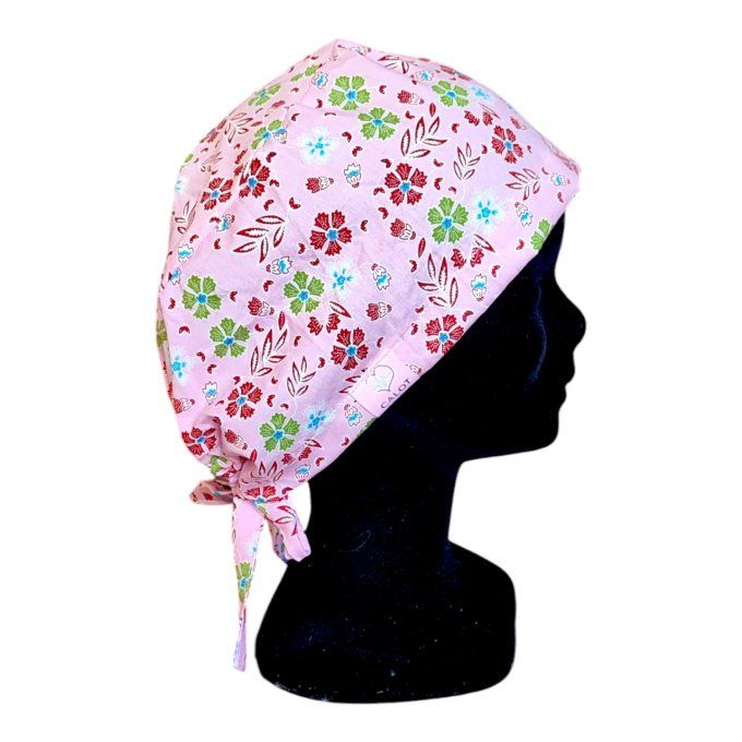 un fond rose tendre orné de petites fleurs en rouge, vert et bleu, agrémenté de feuilles subtiles po