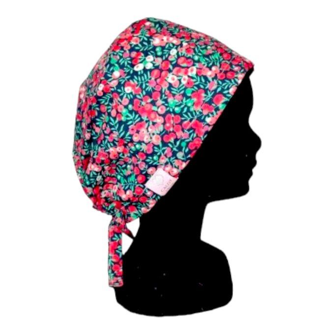 son tissu rouge intense est orné de délicates fleurs aux nuances de rose et de vert, apportant une t
