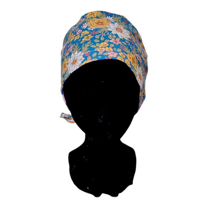 un fond bleu éclatant agrémenté de motifs floraux aux tons dorés, blancs et roses pour une touche de