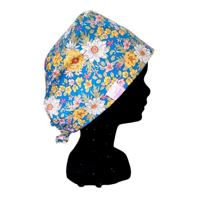 un fond bleu éclatant agrémenté de motifs floraux aux tons dorés, blancs et roses pour une touche de