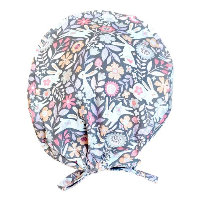 sur un fond noir pastel se dessinent de jolis lapins blancs entourés de fleurs colorées et de feuill