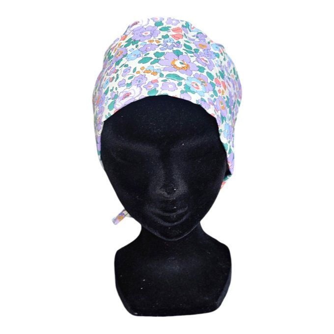 son tissu clair est sublimé par un motif délicat de fleurs aux teintes violettes, parsemé de touches