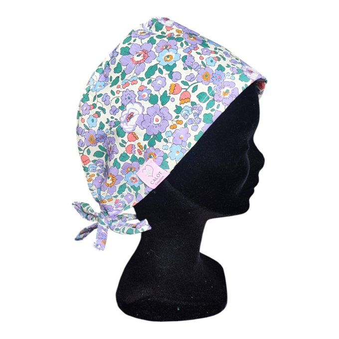 son tissu clair est sublimé par un motif délicat de fleurs aux teintes violettes, parsemé de touches