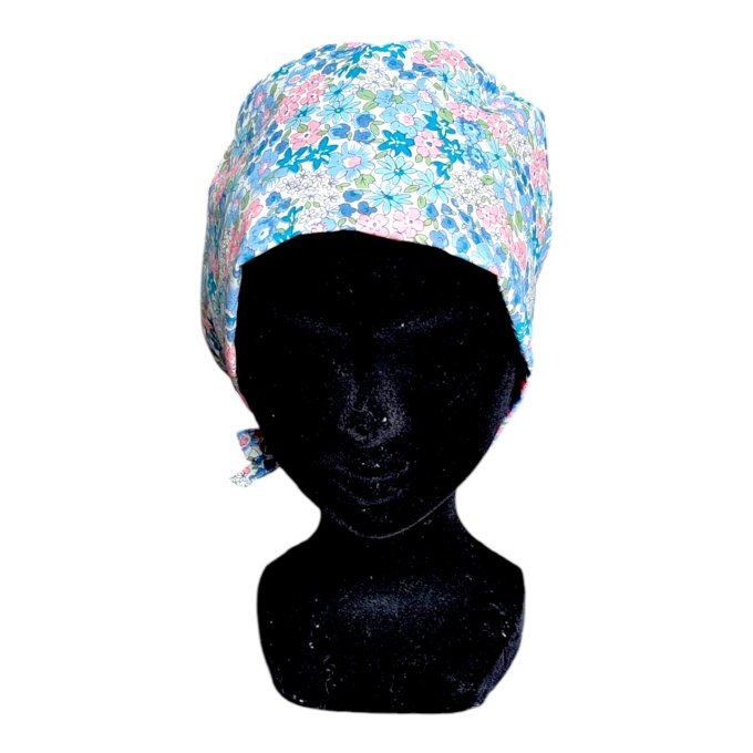 son tissu bleu clair est orné de délicats motifs floraux dans des tons pastel de rose, bleu et vert,