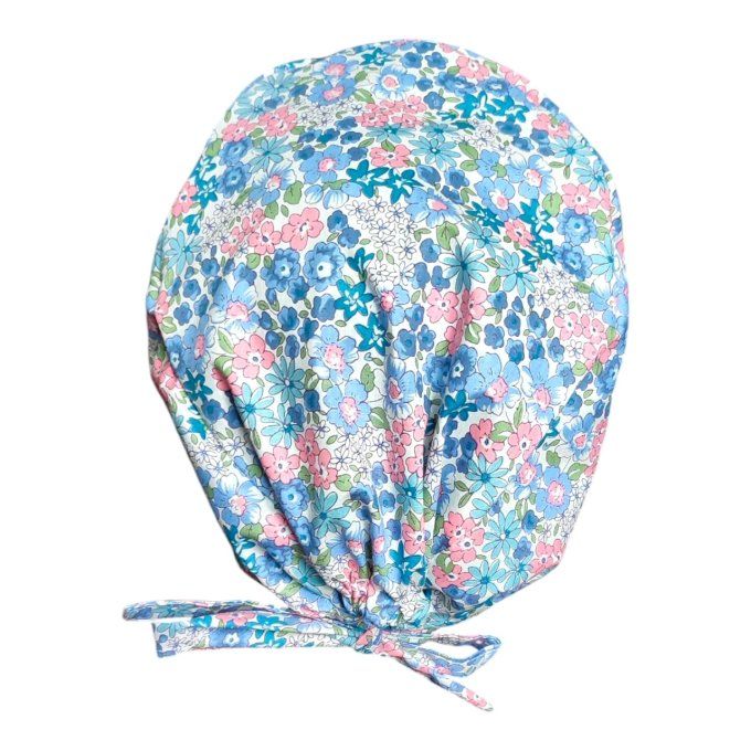 son tissu bleu clair est orné de délicats motifs floraux dans des tons pastel de rose, bleu et vert,