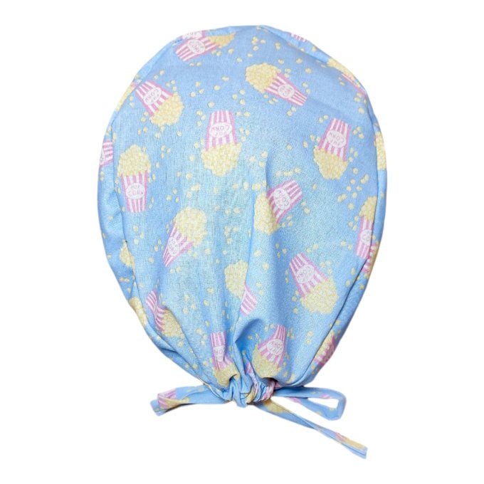 un fond bleu ciel parsemé de boîtes de popcorn rayées rose et blanc, avec des grains de maïs soufflé