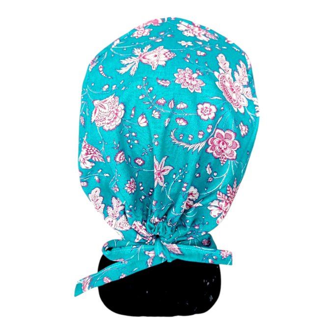 son tissu bleu turquoise est délicatement orné de motifs floraux roses et blancs, apportant une touc
