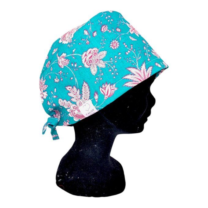 son tissu bleu turquoise est délicatement orné de motifs floraux roses et blancs, apportant une touc