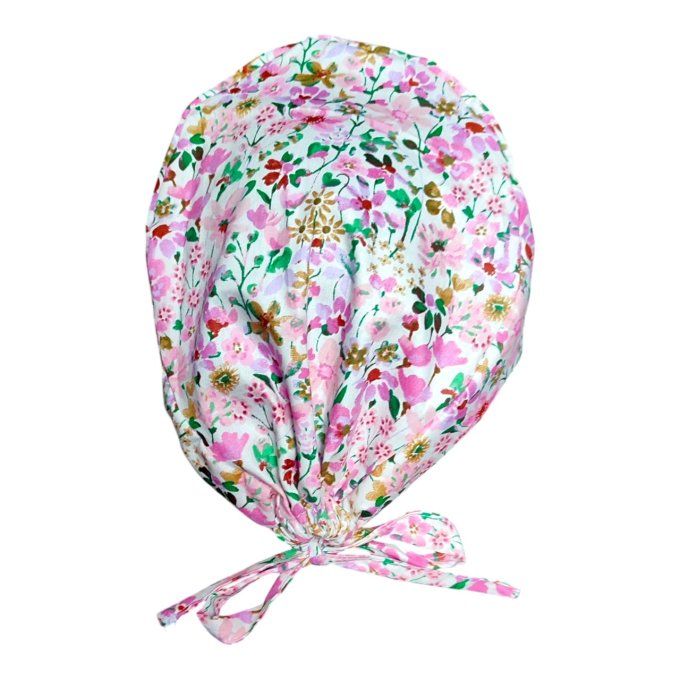 son tissu blanc est délicatement orné de fleurs dans des nuances de rose et de doré, offrant une tou