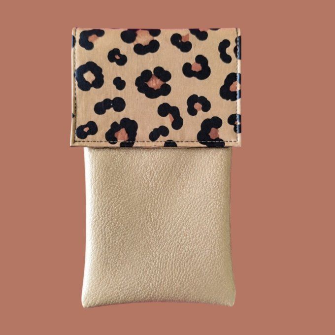 Un imprimé léopard beige aux grandes taches noires et caramel, associé à un similicuir doré champagn