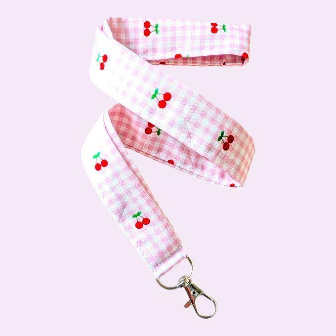 Un vichy rose tendre parsemé de petites cerises rouge et vert — frais, rétro et terriblement joyeux.