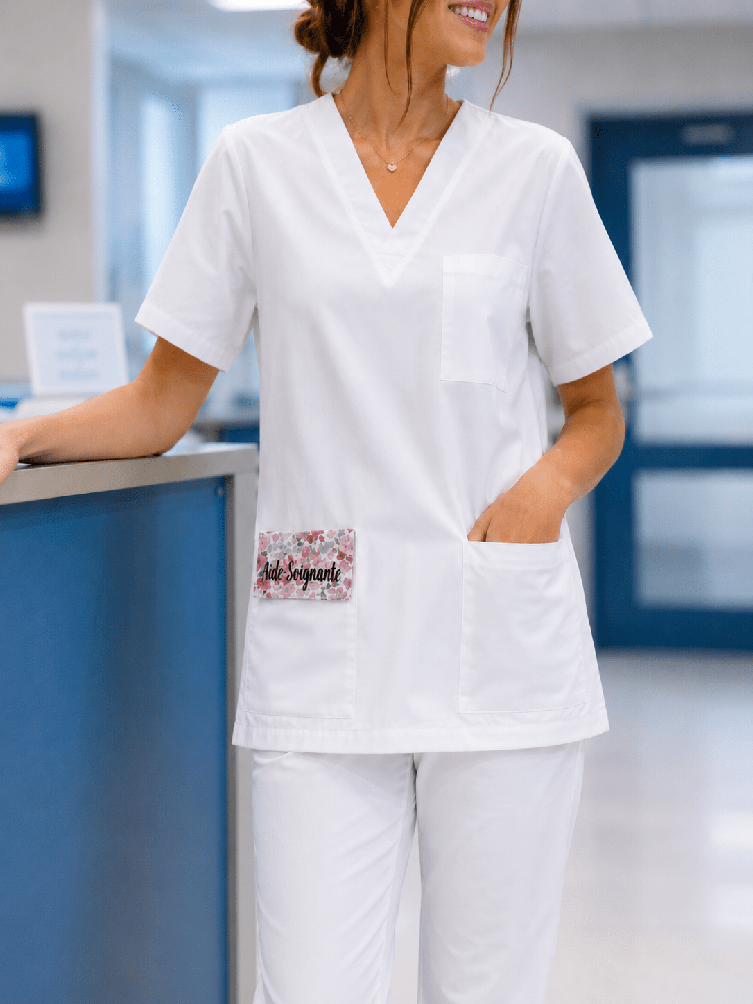 Infirmière en blouse blanche portant la pochette aimantée personnalisée Anne Sophie – Calot Création
